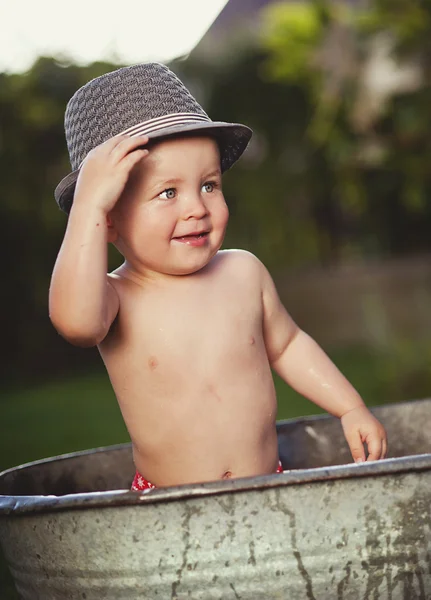 Menino de chapéu tomando banho na banheira galvanizada — Fotografia de Stock