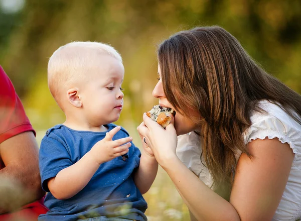 Menino está alimentando a mãe com bolo de muffin — Fotografia de Stock