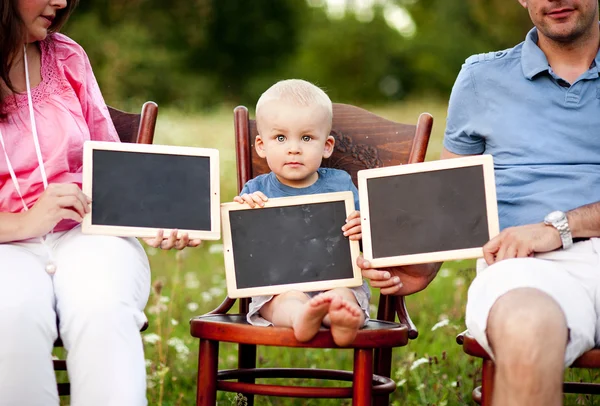 Famiglia con ragazzo seduto su sedie — Foto Stock