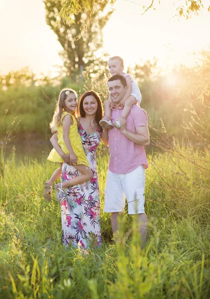 Glad familj i solig äng — Stockfoto