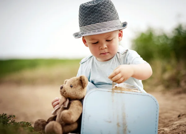 Niño jugando con osito de peluche — Foto de Stock