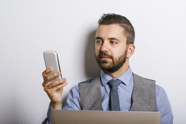 Homme d'affaires utilisant un téléphone intelligent et un ordinateur portable — Photo