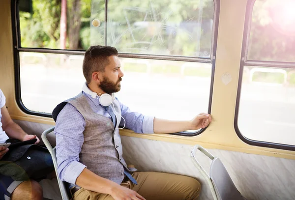 Человек в наушниках, путешествующий на трамвае — стоковое фото