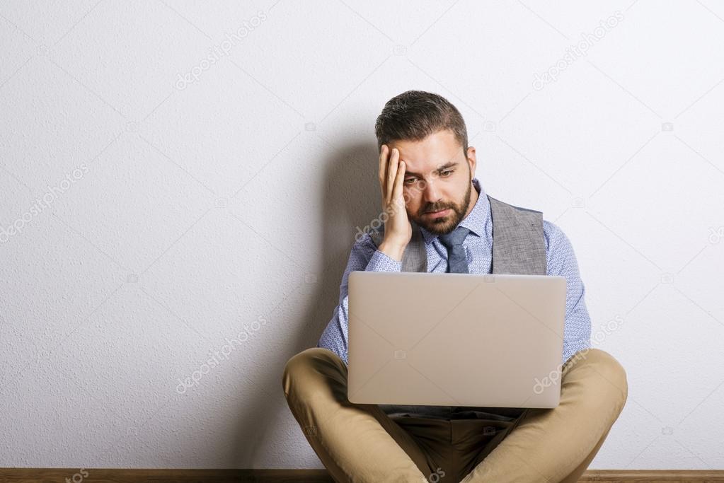Tired businessman working on laptop