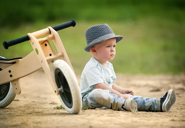 Mały chłopiec z drewnianymi trójkołowy — Zdjęcie stockowe