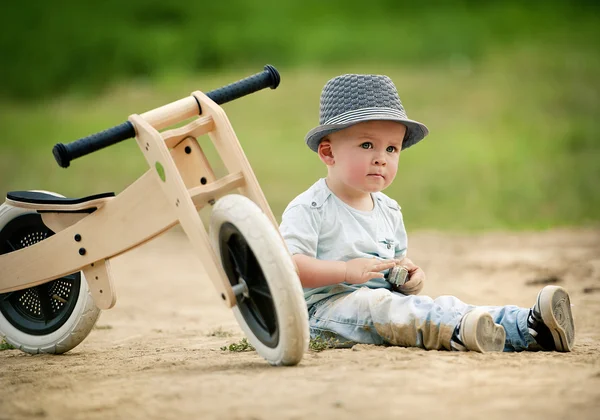 Petit garçon avec tricycle en bois — Photo