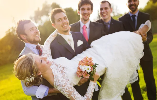 Met zijn vrienden houden bruid bruidegom — Stockfoto