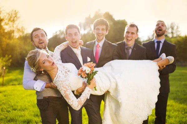 Bräutigam mit seinen Freunden hält Braut — Stockfoto