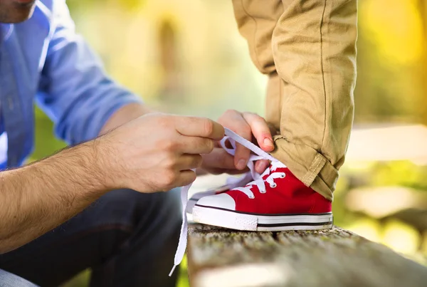 Father is helping his son to tie shoes — Stock Photo, Image