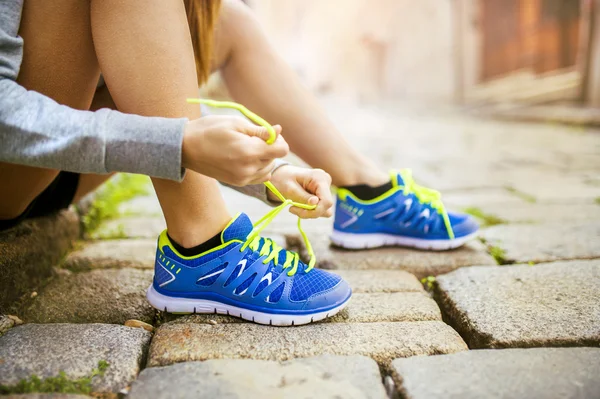 Athlète féminine attachant chaussures de sport — Photo