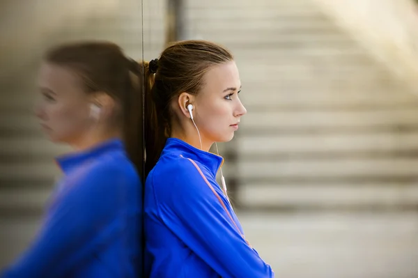 Runner is having break and listening to music — Stock Photo, Image