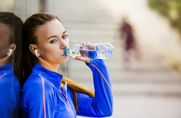 Vrouwelijke atleet drinkwater tijdens de run — Stockfoto