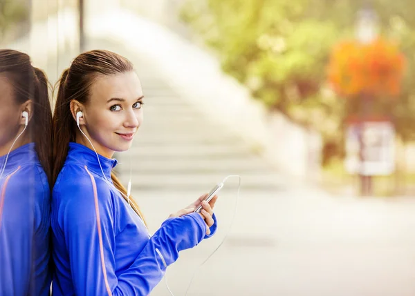 Läufer macht Pause und hört Musik — Stockfoto