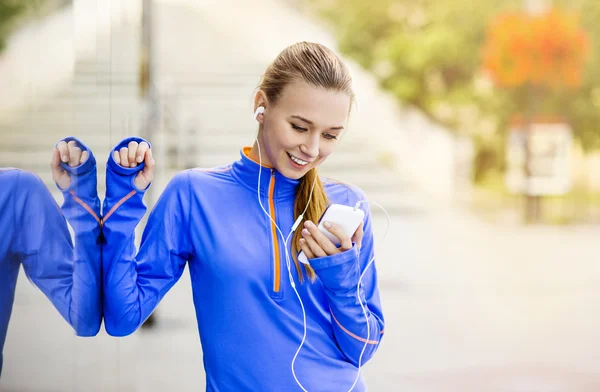 Runner está tendo pausa e ouvir música — Fotografia de Stock