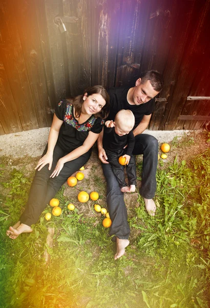 Family with little boy having fun with oranges — Stock Photo, Image