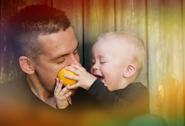 Vader en zoon eten oranje — Stockfoto
