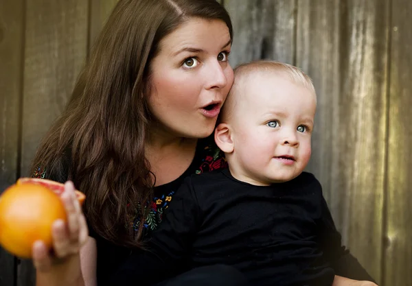 Matka a malý syn jí oranžová — Stock fotografie