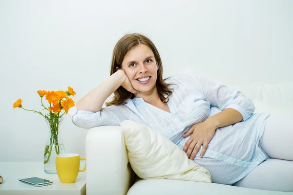 Femme enceinte couchée sur le canapé — Photo