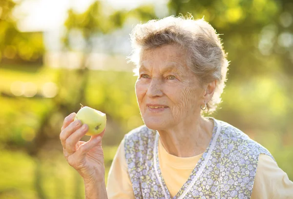 Äldre kvinna äta äpple — Stockfoto