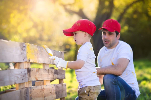 Padre con hijo pintando cerca de madera — Foto de Stock