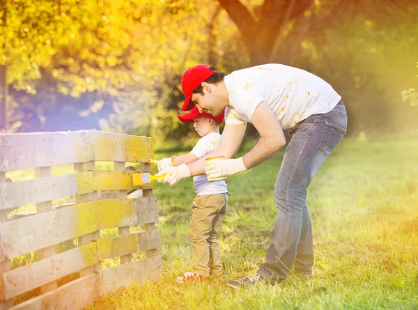 Padre con hijo pintando cerca de madera — Foto de Stock