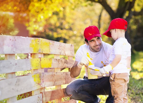 Padre con hijo pintando cerca de madera — Foto de Stock