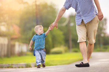 Küçük oğlunun elini tutan baba