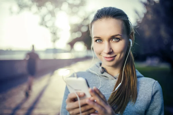 Runner is having break and listening to music — Stock Photo, Image