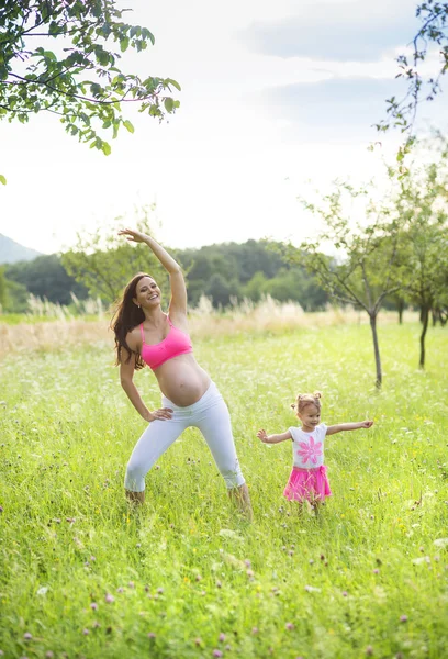 Donna con sua figlia pratica pilates — Foto Stock