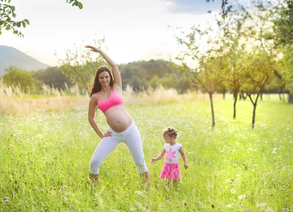 Frau mit ihrer Tochter praktiziert Pilates — Stockfoto