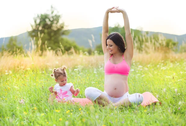 Kvinna med sin dotter göra övningar — Stockfoto