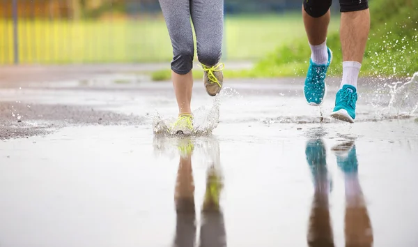 Pareja corriendo bajo la lluvia . — Foto de Stock