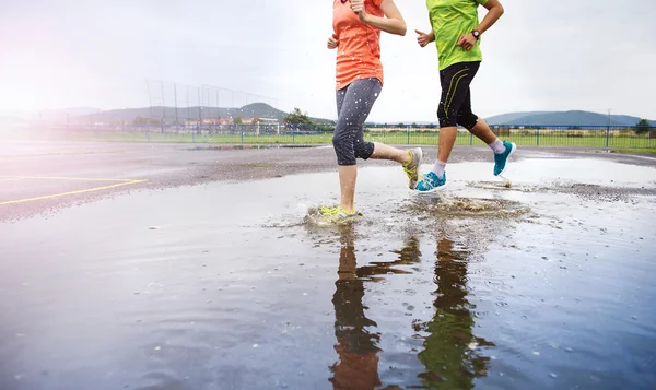 Par är joggning i regn. — Stockfoto