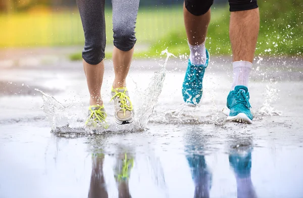 Pareja corriendo bajo la lluvia . — Foto de Stock