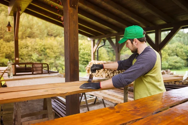 Handyman varnishing pine wooden planks — Stock Photo, Image