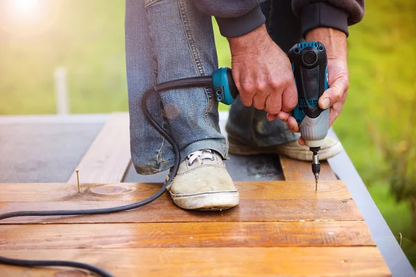 Homme à tout faire installant des planchers dans le patio — Photo