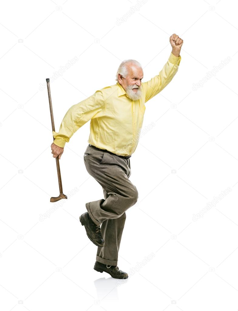 Bearded man jumping with cane in his hand