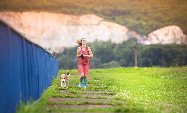 Chica corriendo con su perro — Foto de Stock