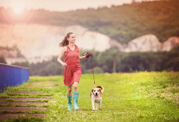 Girl running with her dog — Stock Photo, Image