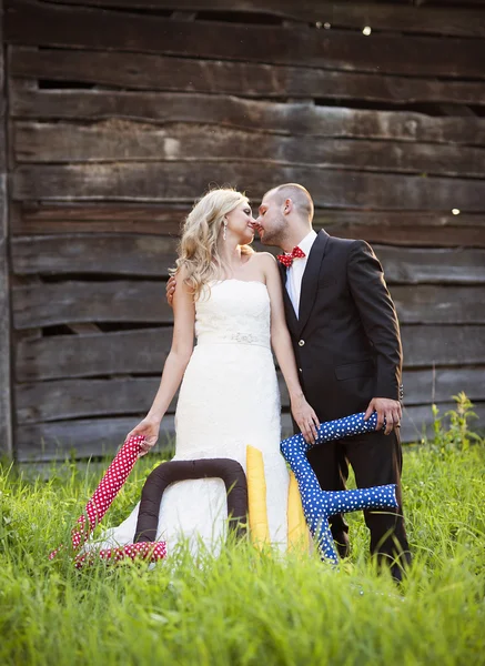 Bruden och brudgummen med älskar kuddar — Stockfoto