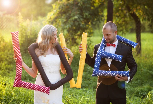 Bruid en bruidegom met liefde kussens — Stockfoto