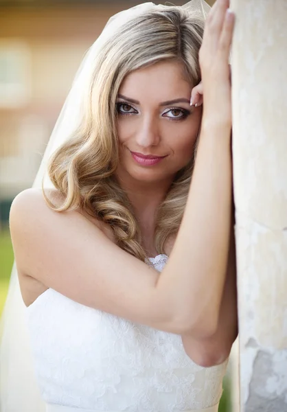 Bride with veil posing by old house — Stock Photo, Image