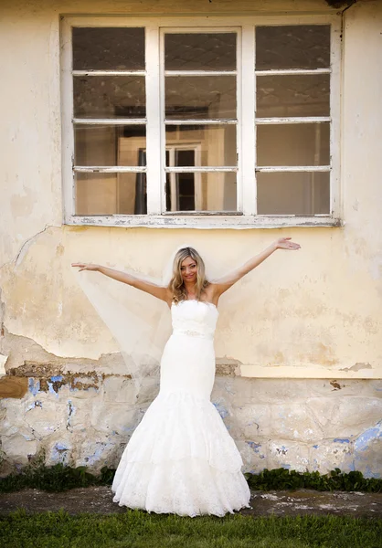 Bride with veil posing by old house — Stock Photo, Image