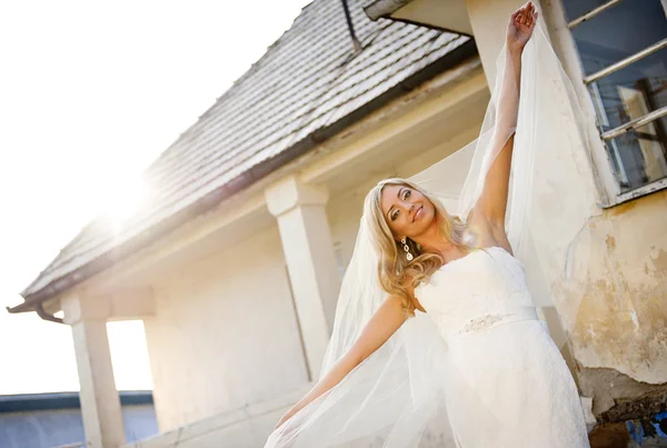 Bride with veil posing by house — Stock Photo, Image