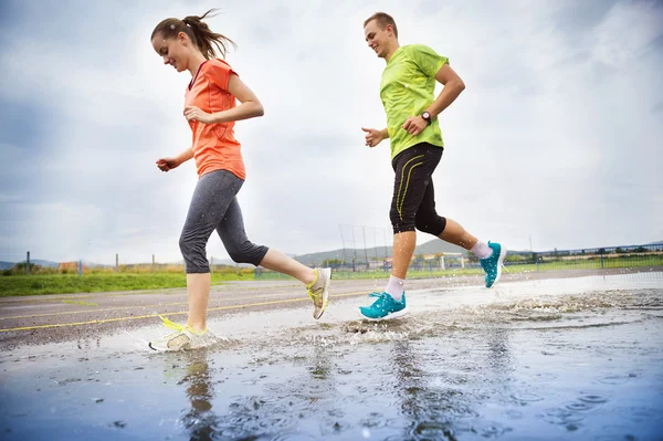 Couple running in rainy weather — Stock Photo, Image