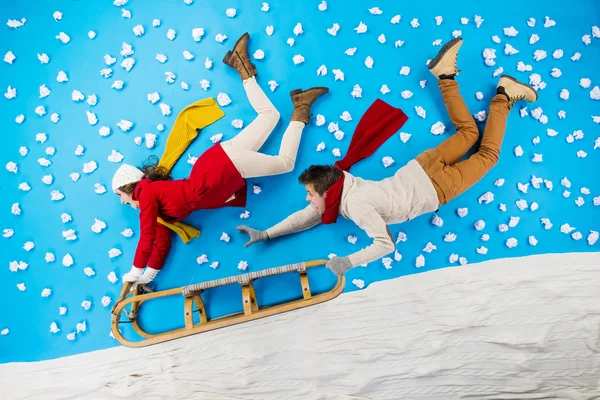 Young couple on sledge having fun — Stock Photo, Image