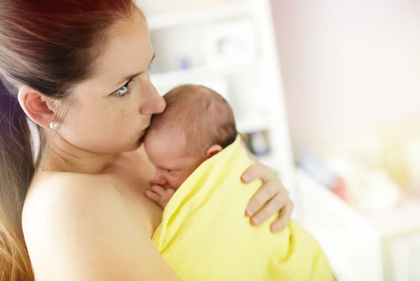 Mother kissing her newborn baby girl — Stock Photo, Image
