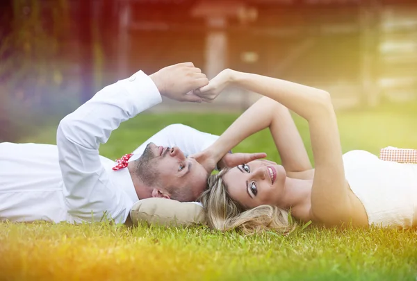 Bride and groom lying on grass — Stock Photo, Image