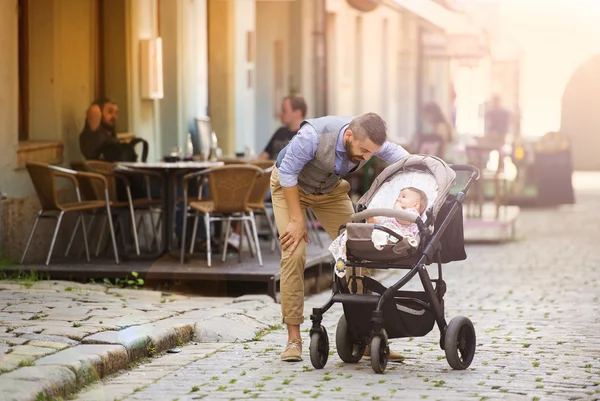 Homme à la barbe marchant avec bébé en landau — Photo