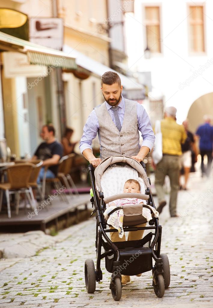 Man with beard walking with baby in pram — Stock Photo © halfpoint